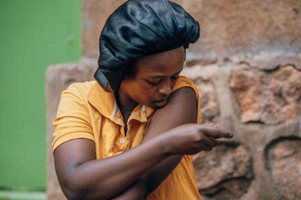 Woman in Rwanda giving herself medication